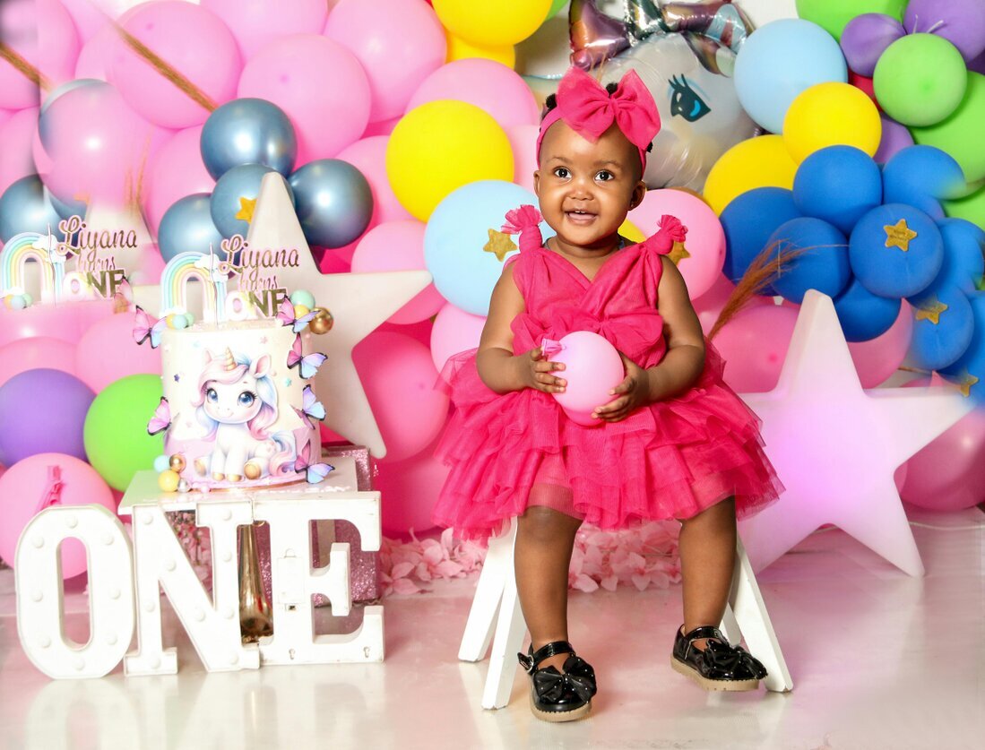 Niños soplando velas en un cumpleaños infantil con globos de colores